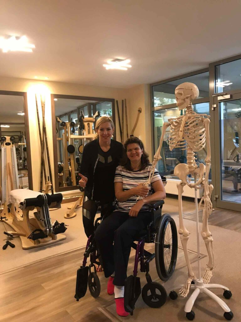 sérülés után gyógytornát végző kerekesszékes nő a mozgásterapeutával ülve